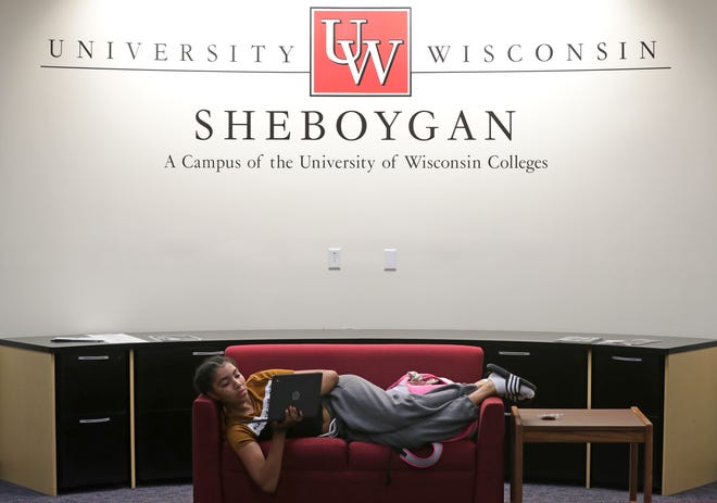 A University of Wisconsin-Green Bay, Sheboygan Campus student relaxes on a couch and works on her laptop while waiting for a class. The Sheboygan campus will see one of the highest rises in student fees next year: $124 over two semesters.