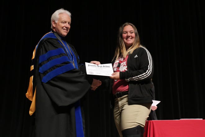 Principal Karl Carpenter presents a certificate to freshman Paige Seitz at Pineville High School's "Commitment to Commencement" ceremony.