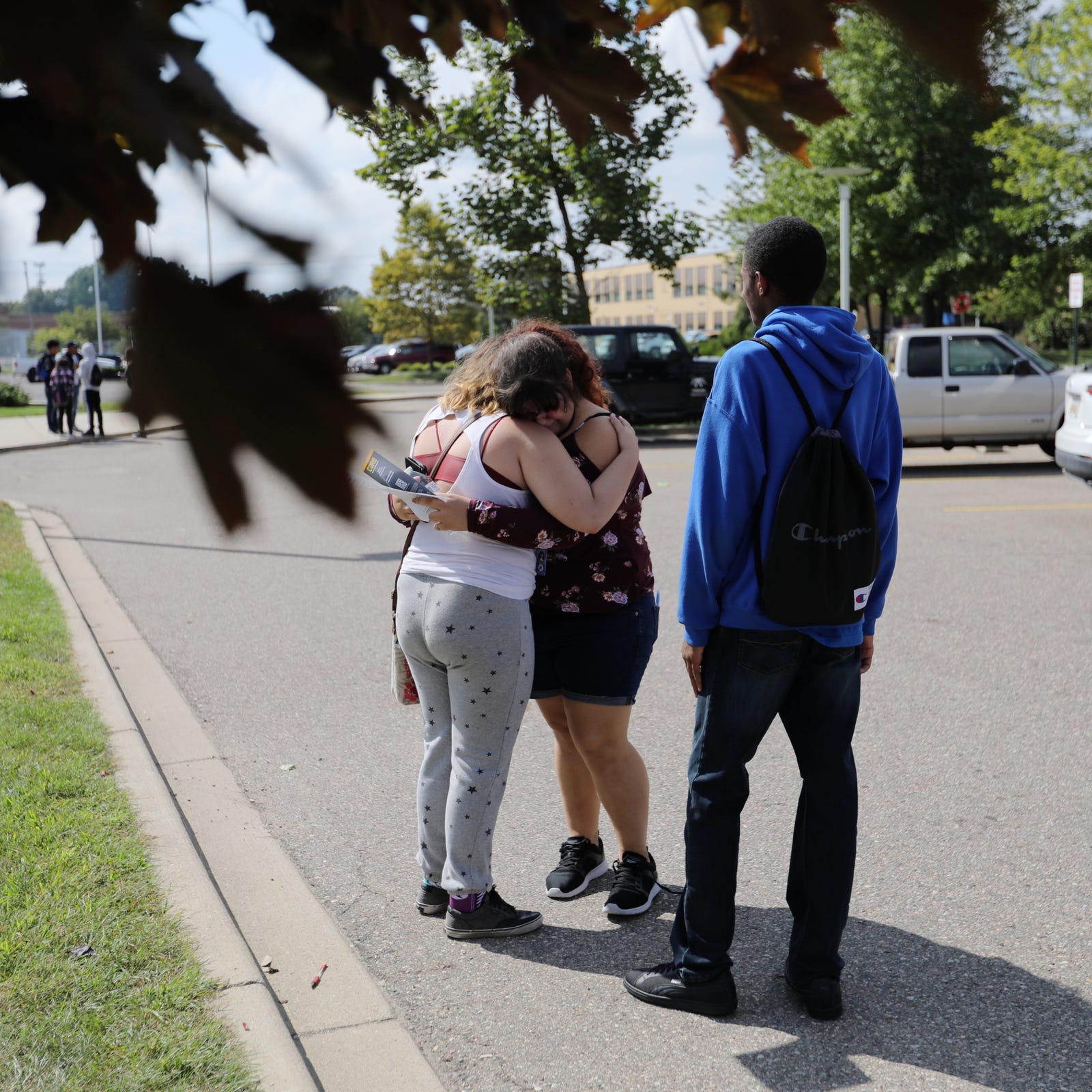 Victoria Oraczko, center, 16, of Warren is comforted by her friends after she was interviewed and released after the stabbing that occurred in her classroom at Fitzgerald High School in Warren, Mich. on Wednesday, Sept. 12, 2018.