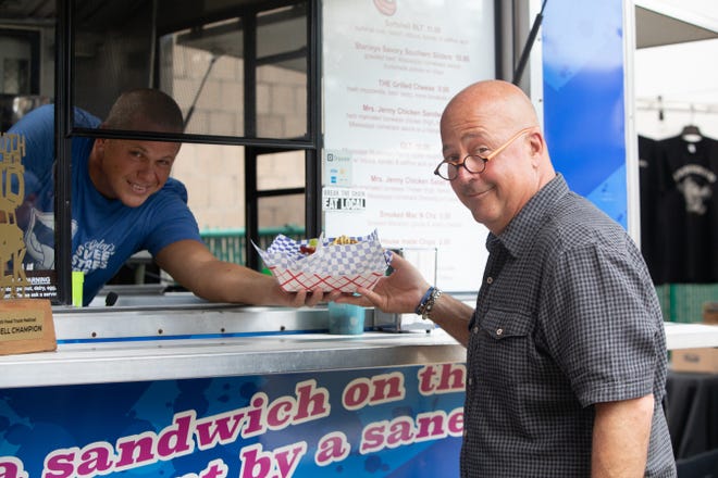 Mike Stanley hands Andrew Zimmern his order in his food truck Stanley's Sweet Street Treats, as seen on Big Food Truck Tip, Season 1.