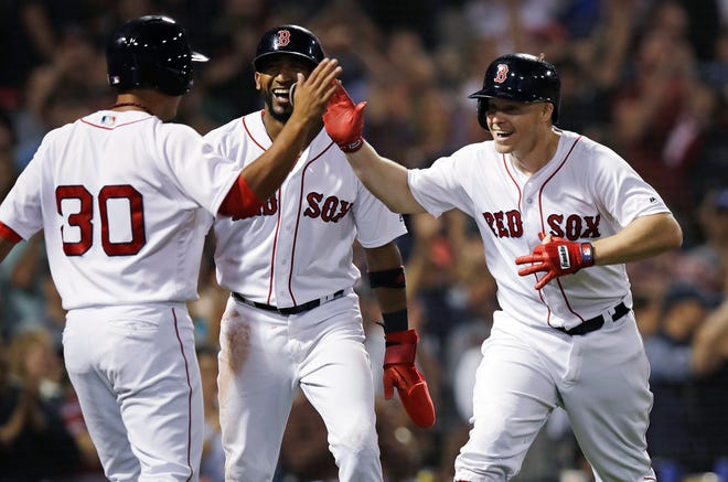 Boston Red Sox's Brock Holt, right, celebrates with Tzu-Wei Lin (30) and Eduardo Nunez, center, after his pinch-hit, three-run home run off Toronto Blue Jays relief pitcher Ryan Tepera during the seventh inning of a baseball game at Fenway Park in Boston, Tuesday, Sept. 11, 2018. (AP Photo/Charles Krupa)