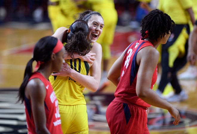 Seattle Storm forward Breanna Stewart, center, celebrates and hugs guard Sue Bird (10) after Game 3 of the WNBA finals as members of the Washington Mystics walk off the court on Wednesday.