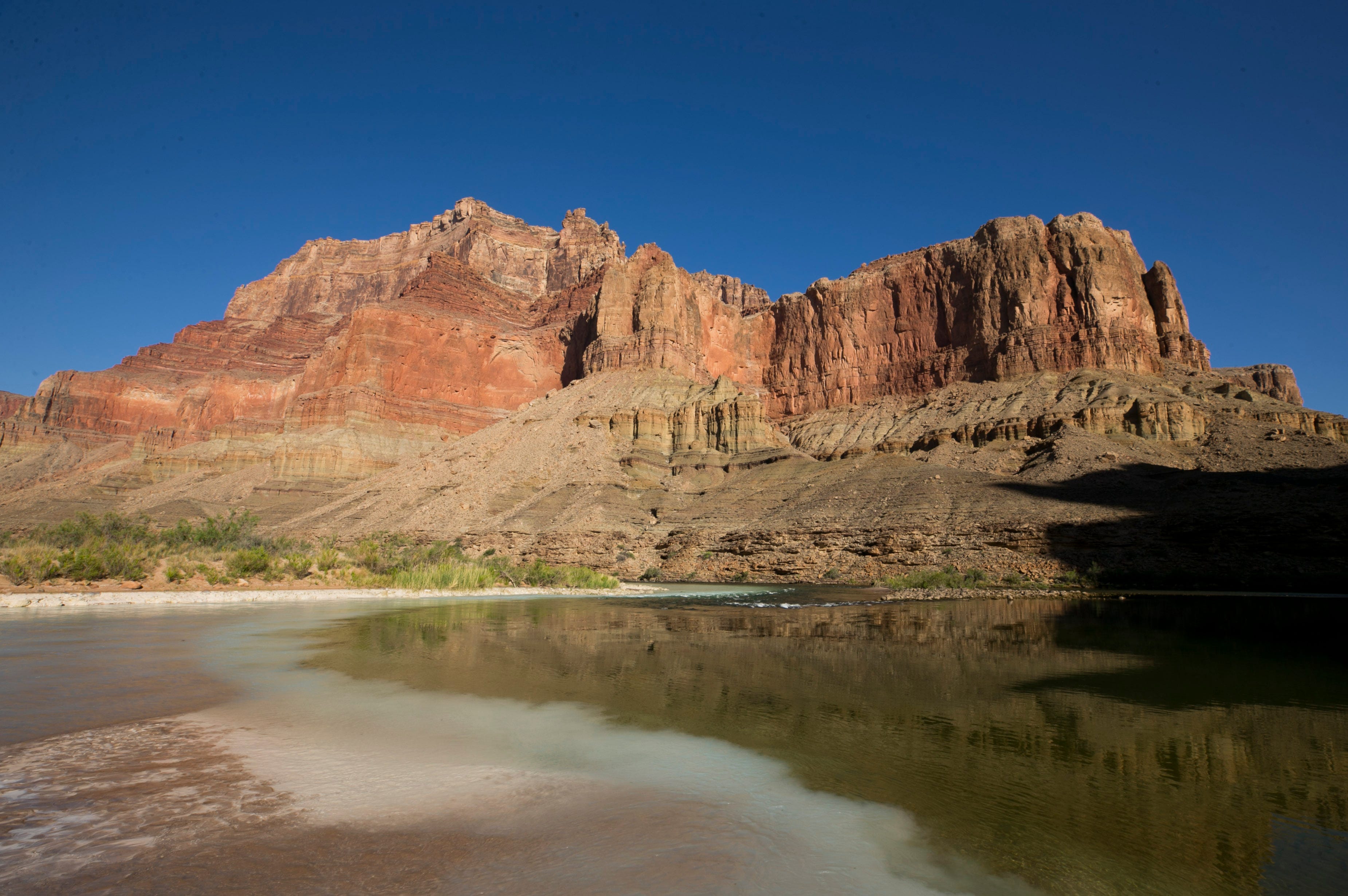 Aqua-blue, calcium carbonate-rich water from the Little Colorado River (left) mixes with water from the Colorado River in Grand Canyon National Park.