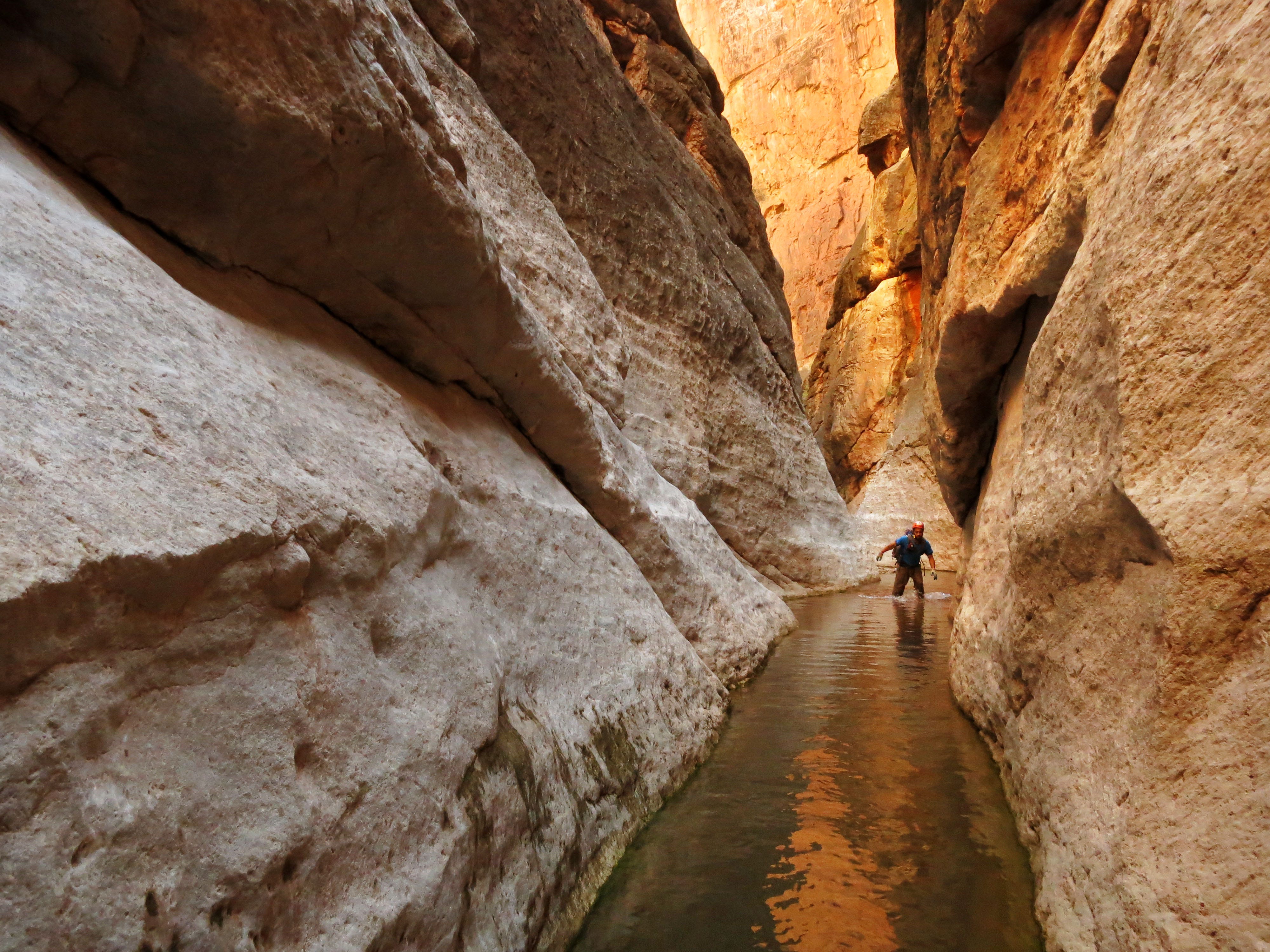 Eric Luth wades through water in the redwall narrows of a side canyon of the Colorado River in Grand Canyon National Park. Hundreds of side canyon drainages meet the Colorado River in Grand Canyon and offer a glimpse into something not impacted by Glen Canyon Dam.