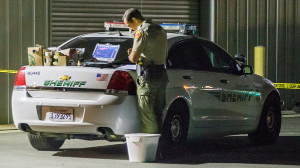 A Kern County sheriff's deputy stands near a...