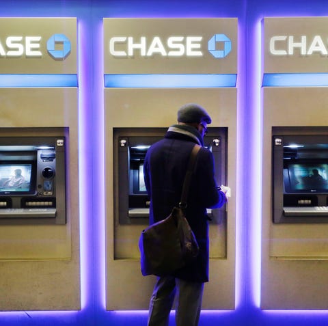 A customer uses an ATM at a branch of Chase Bank, 