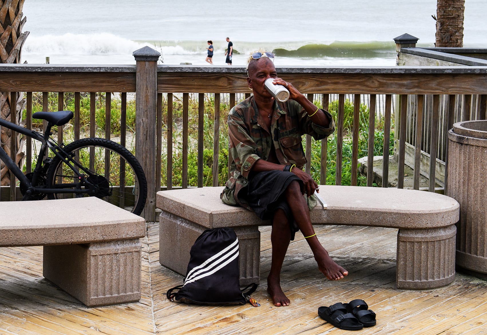 Shane "Rooster" Bacchus, a homeless man living in Myrtle Beach, S.C., takes a drink from his water bottle at the Myrtle Beach Boardwalk and Promenade on Sept. 13, 2018. Bacchus said he will be sleeping in a truck during Hurricane Florence.