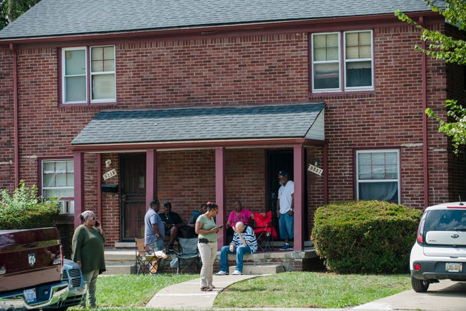 A number of people hangout on the porch in front of an apartment in the 9200 block of Evergreen on Detroit's westside Friday afternoon, September 14, 2018, where earlier in the day a 46-year-old man was shot and killed by police during the execution of a search warrant in connection with the death of a 5-year-old girl late Thursday, according to Detroit police. Irate family members of the unidentified man said at the scene he had nothing to do with the girl's death and say police were doing a search of the home at 4:50 a.m. in a scene that jolted the neighborhood.