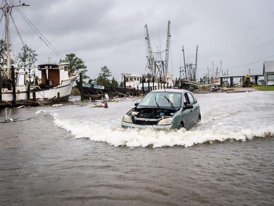 A motorist travels through a flooded area of ​​Swan Quarter Harbor, in the Swan area of ​​North Carolina.