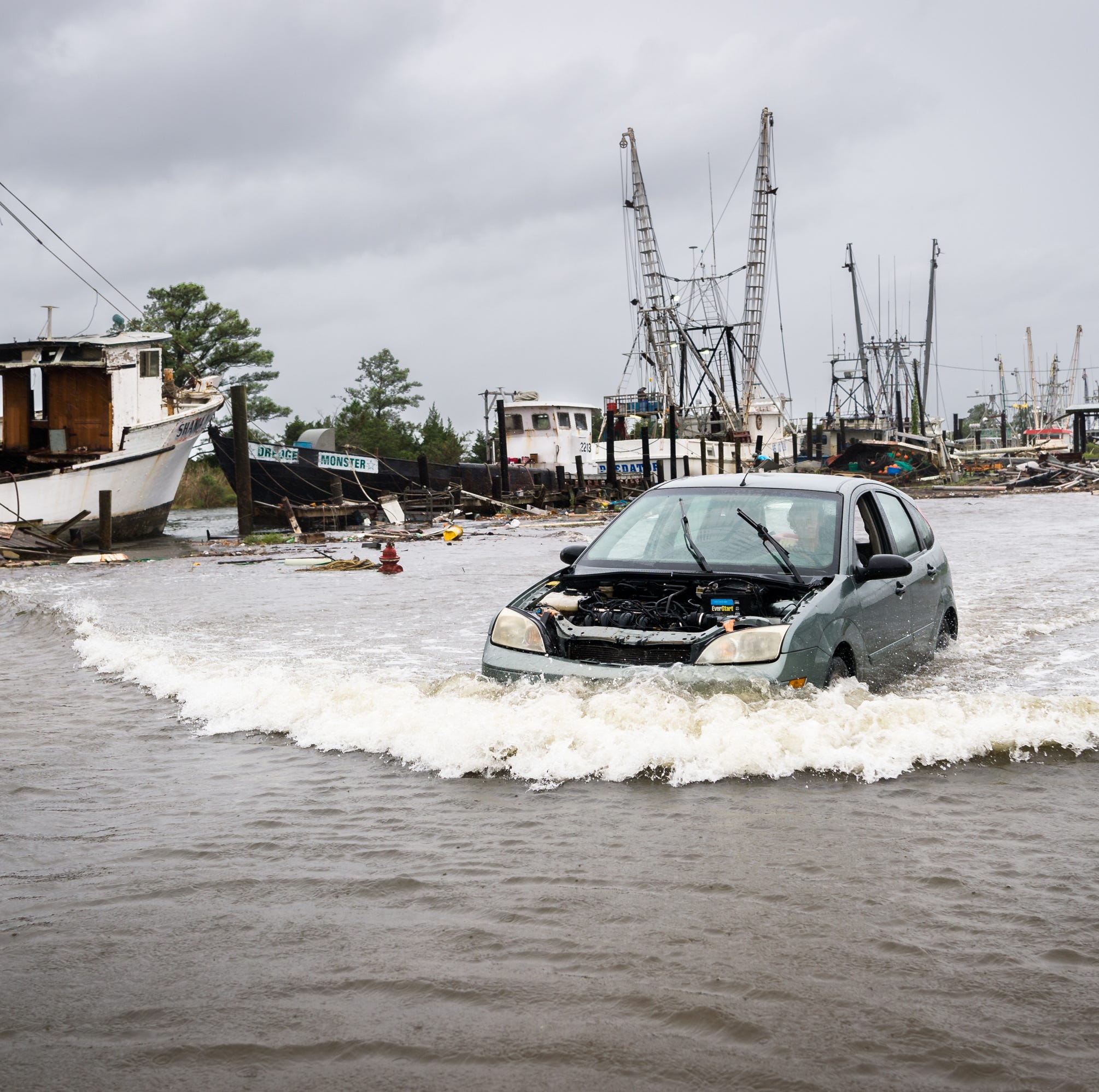 A motorist drives through a flooded area in the Swan Quarter harbor in Swan Quarter, North Carolina.