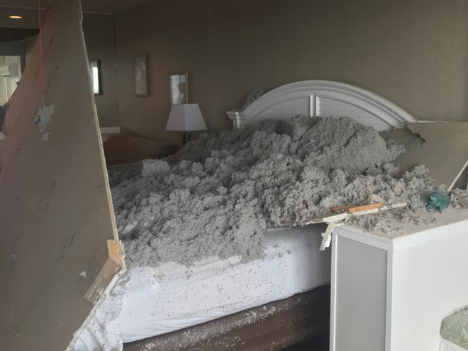 Drywall sheeting and insulation lie on the bed after a ceiling collapse at a home in Dewey Beach as a couple from Milford slept.