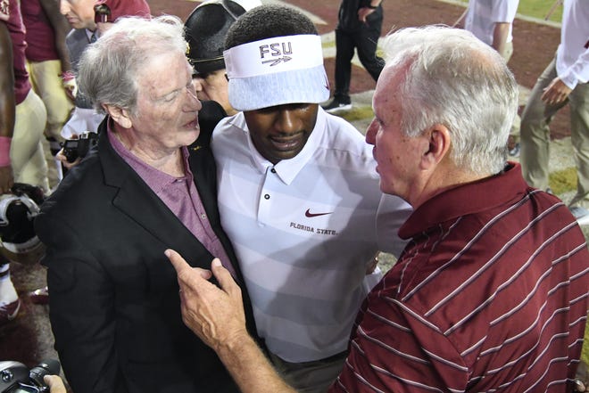 FSU head coach Willie Taggart talking to FSU President Thrasher after his first career win at Florida State.