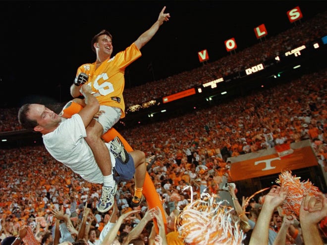 A fan wearing a Peyton Manning jersey sits on top of what is left of a goalpost as Tennessee fans take over the playing field after the Volunteers defeated Florida 20-17 in overtime in Knoxville on Sept. 19, 1998. Florida had beaten Tennessee for the previous five years.