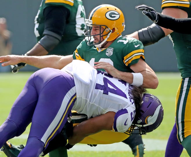 Green Bay Packers quarterback Aaron Rodgers (12) gets roughed by linebacker Eric Kendricks (54) in the 2nd quarter against the Minnesota Vikings Sunday, September 16, 2018 at Lambeau Field in Green Bay, WIs.