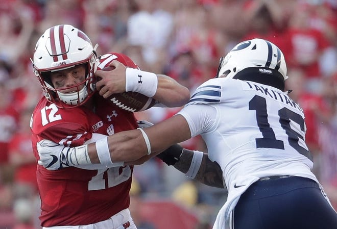 Wisconsin's Alex Hornibrook tries to get away from BYU's Sione Takitaki during their game Saturday.