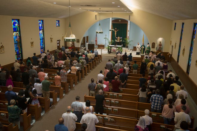 Parishioners listen as the Rev. Matt Worthen celebrates Mass Sunday, Sept. 16, 2018, at Little Flower Catholic Church.
