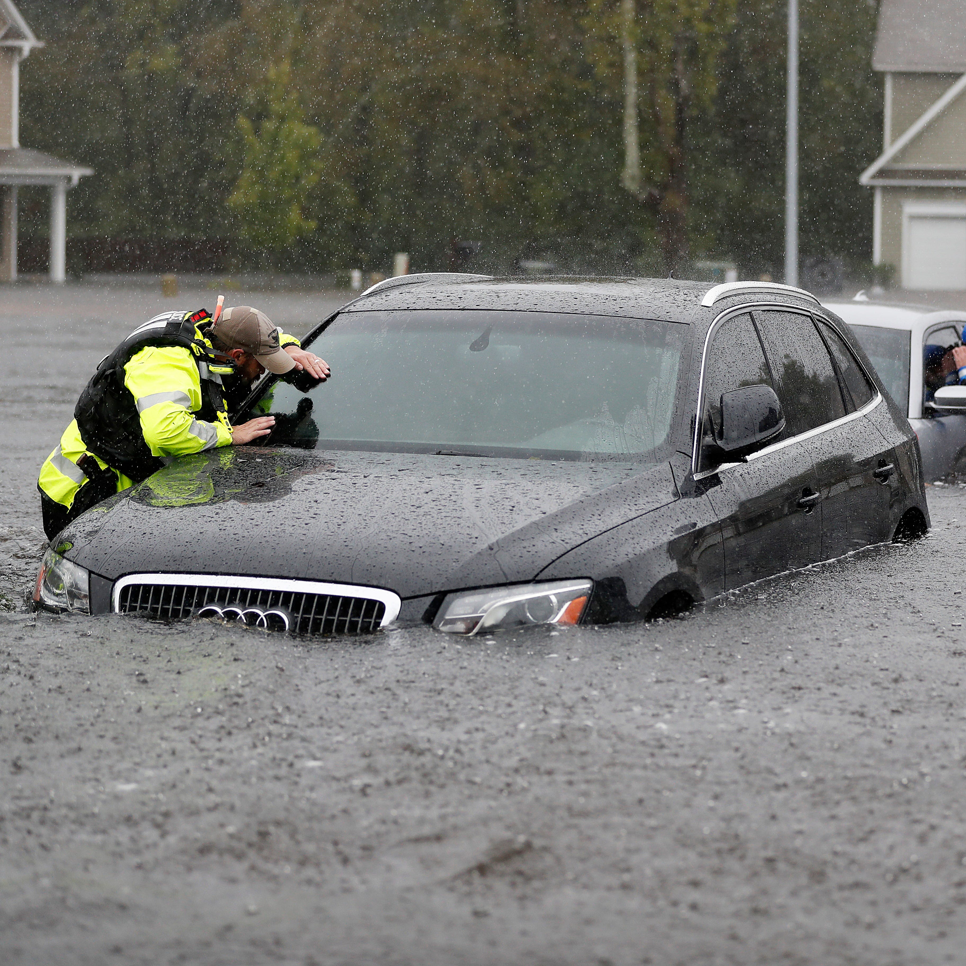 Members of the North Carolina Task Force urban search and rescue team check cars in a flooded neighborhood looking for residents who stayed behind as Florence continues to dump heavy rain in Fayetteville, N.C. on Sept. 16, 2018.