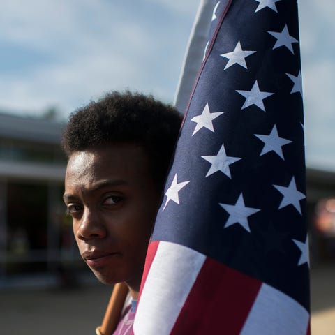John Larrier of Maplewood stands with an American...