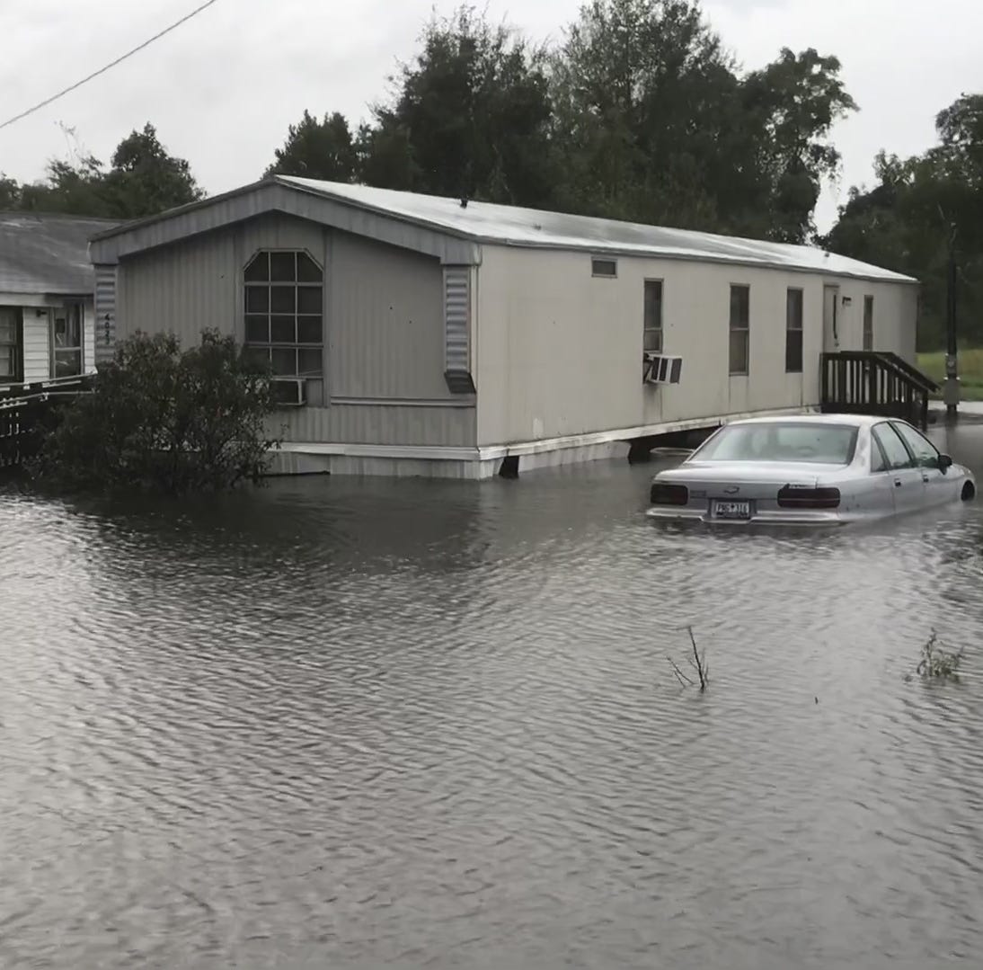 A car next to a mobile home is partially submerged by floodwaters south of Mullins.