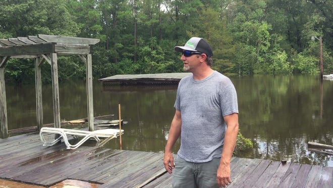 Jess White describes the flooding he's experienced in the aftermath of Hurricane Florence while standing in water that now covers his entire backyard and pool in Conway on Monday, September 17, 2018.