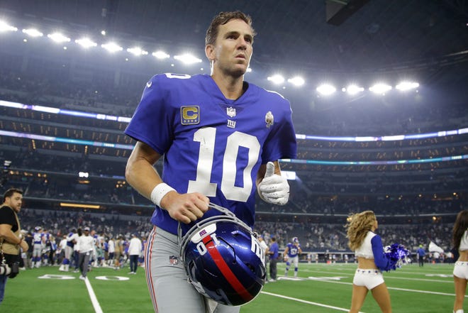 New York Giants quarterback Eli Manning (10) leaves the field after the game against the Dallas Cowboys at AT&T Stadium.