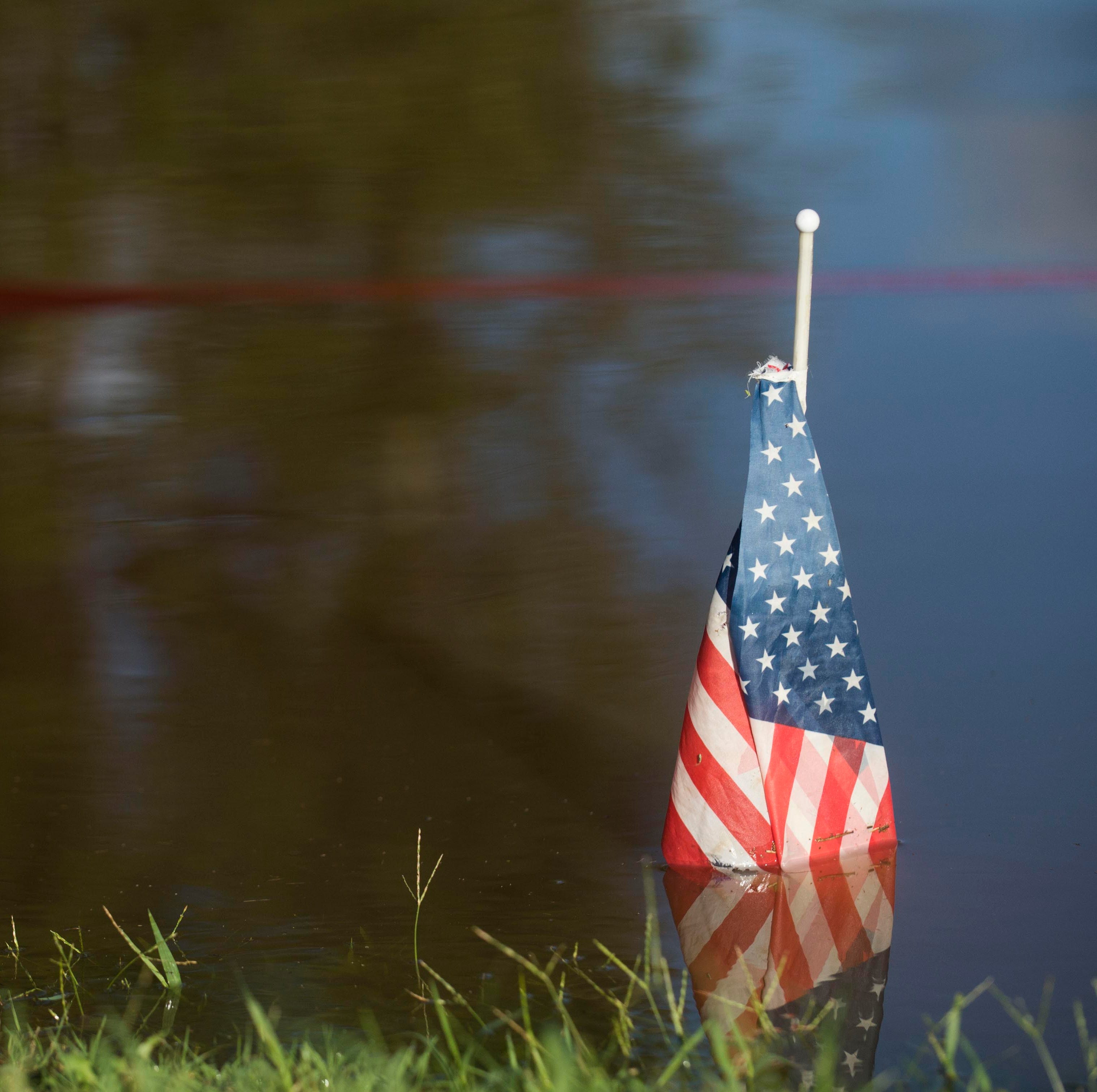 A flag marks where the Cape Fear River rose to during Hurricane Matthew in 2016, outside of Deep Creek Outfitters in Fayetteville, N.C. Tuesday, Sept.18, 2018.  Tuesday morning the river stands inches below 60 feet. The flood stage for the river is 3