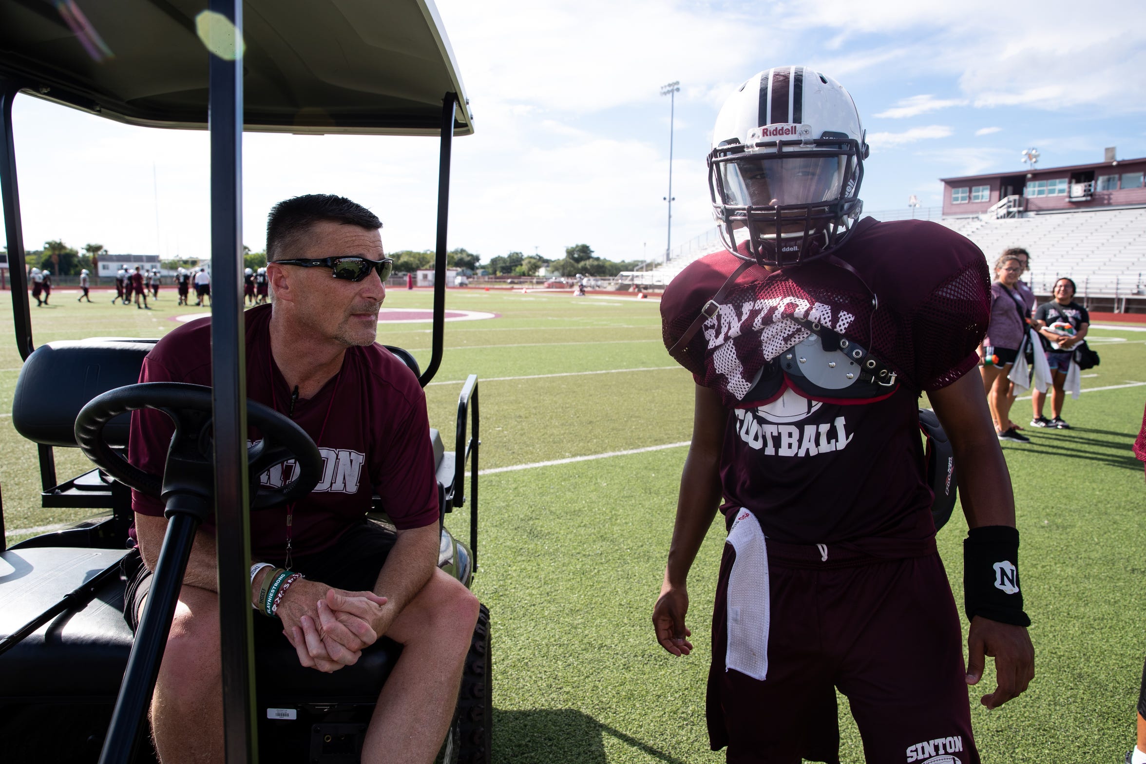 Tom Allen head coach of the Sinton football team talks to one of his players as he sits in his cart during practice at Sinton High School on Tuesday, Sept. 18, 2018. Allen is suffering from a rare neurological disease that has him in a cart during games and practices