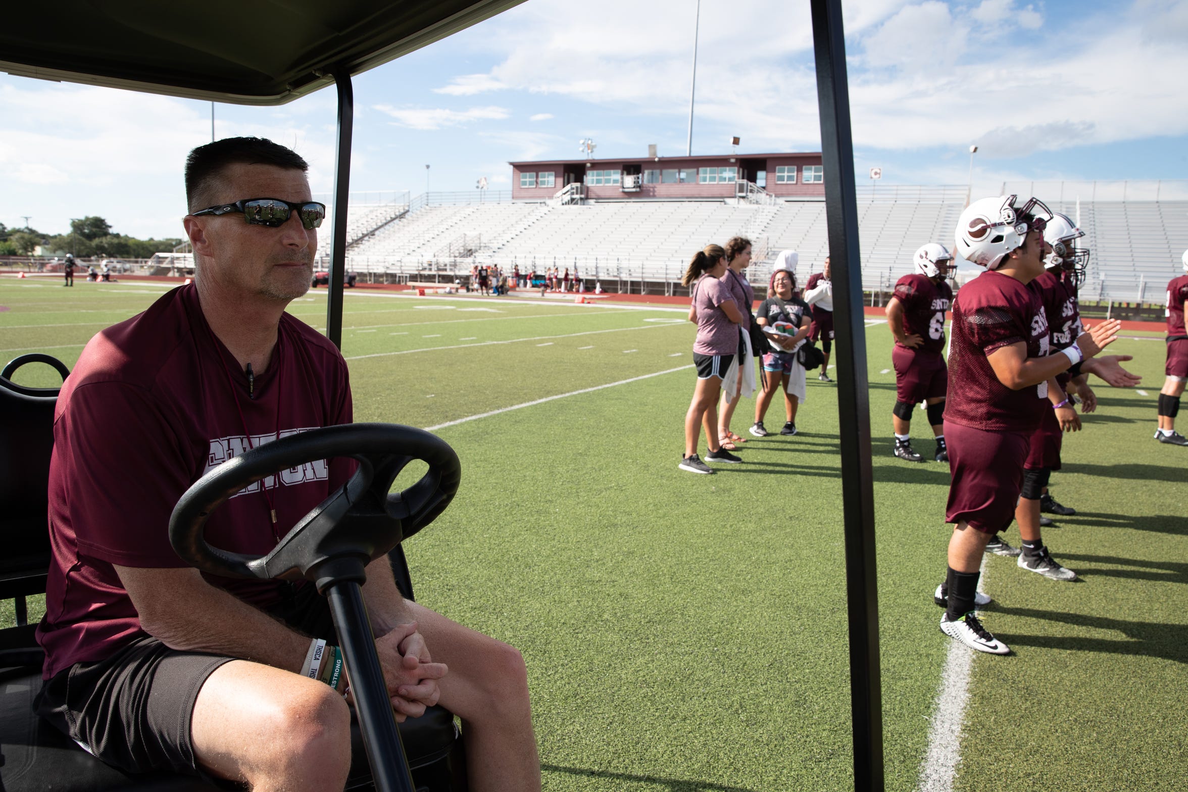 Tom Allen head coach of the Sinton football team watches from his cart as the team runs drills on the field during practice at Sinton High School on Tuesday, Sept. 18, 2018. Allen is suffering from a rare neurological disease that has him in a cart during games and practices