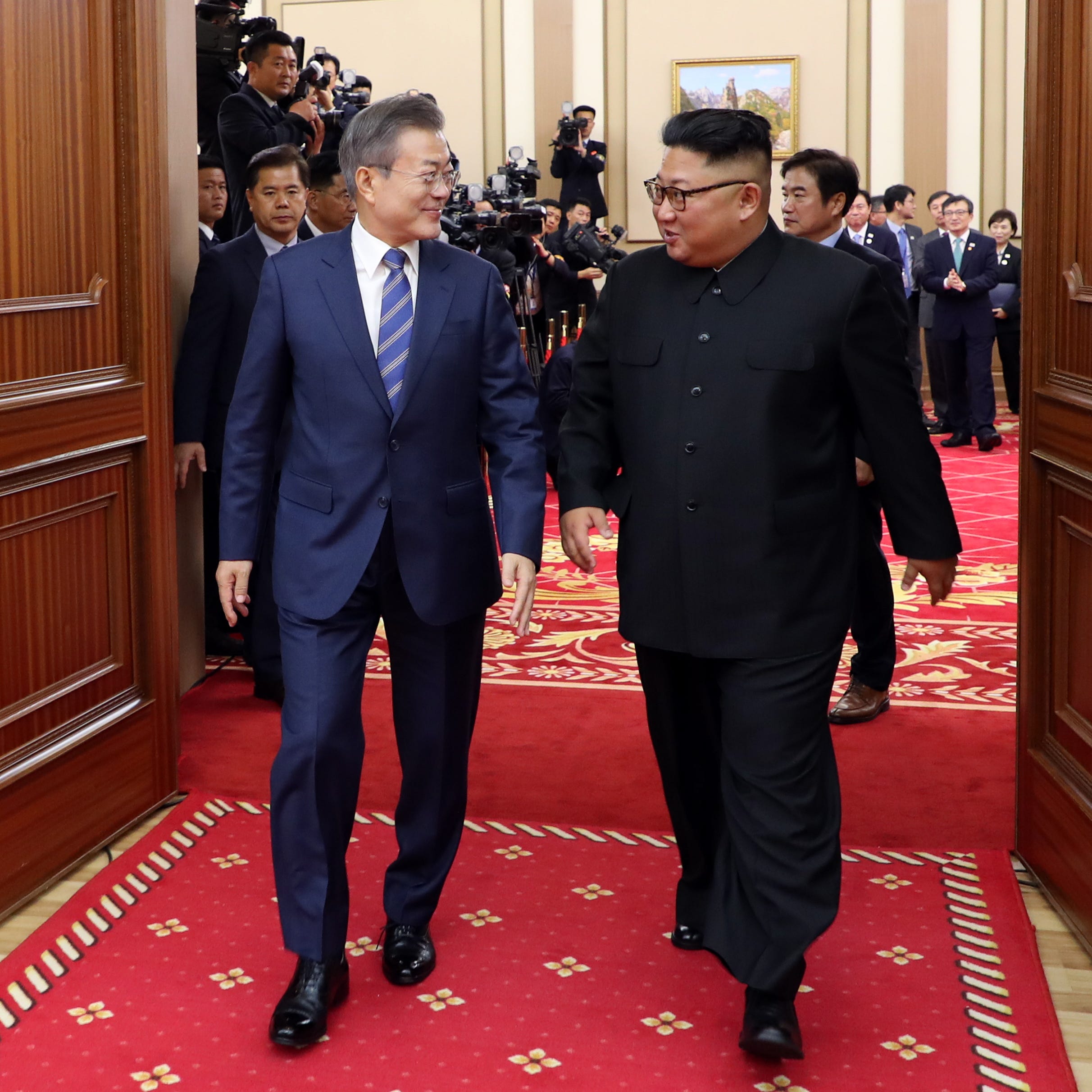 South Korean president Moon Jae-in (L) talks with North Korean leader Kim Jong Un as they leave after a press conference in Pyongyang, North Korea, 19 September 2018.
