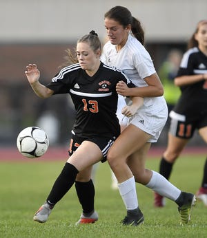 Marion's Chloe DeLyser, left, shields the ball from Gananda's Natalie McLoud during a game this season. DeLyser scored 79 goals this fall and holds the state record with 260 goals with one season left to play.
