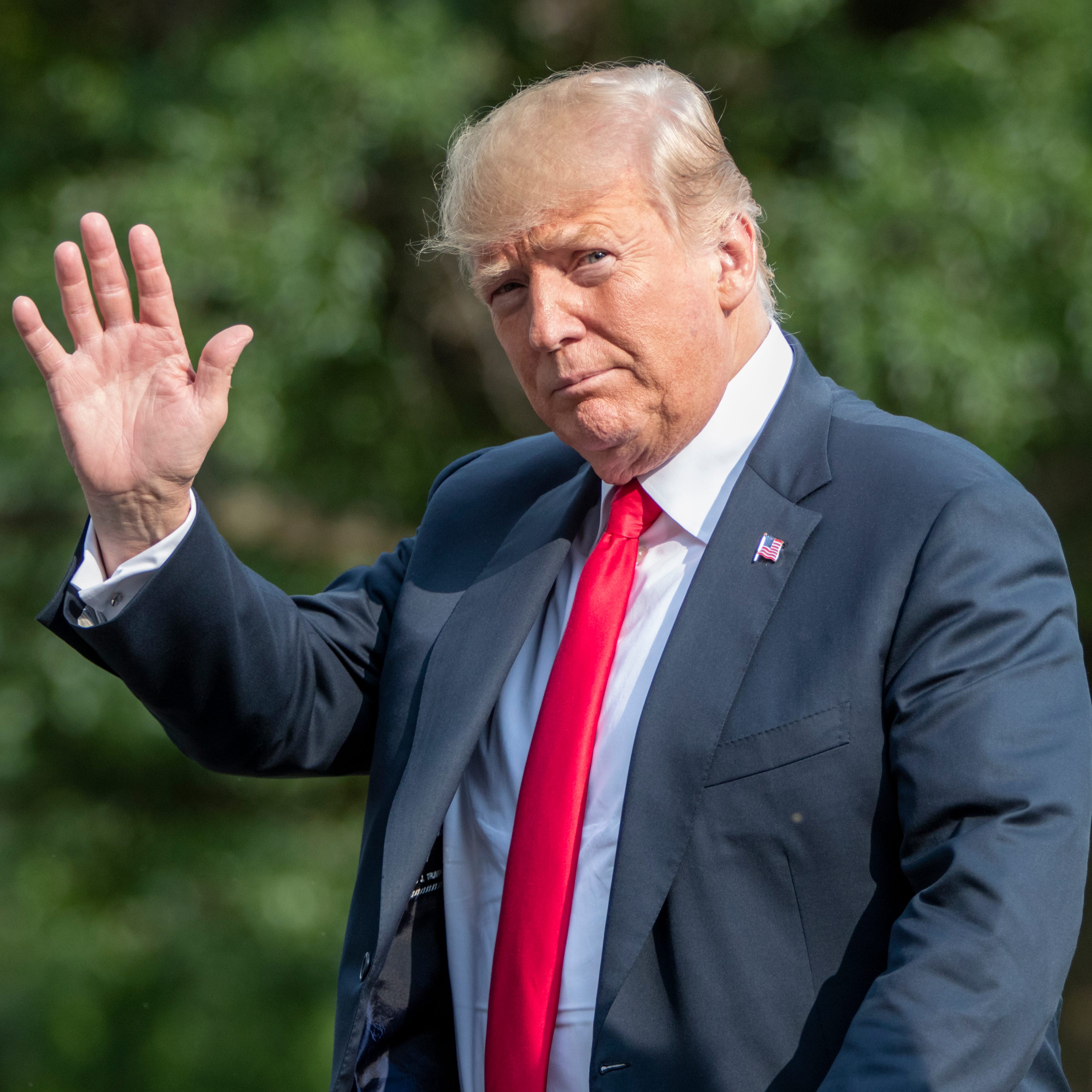 President Donald Trump waves as he arrives at the White House in Washington.