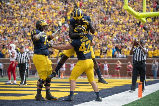 (From left) Michigan offensive lineman Ben Bredeson, tight end Nick Eubanks, and fullback Ben Mason celebrate Mason's first touchdown of the day in the first quarter.