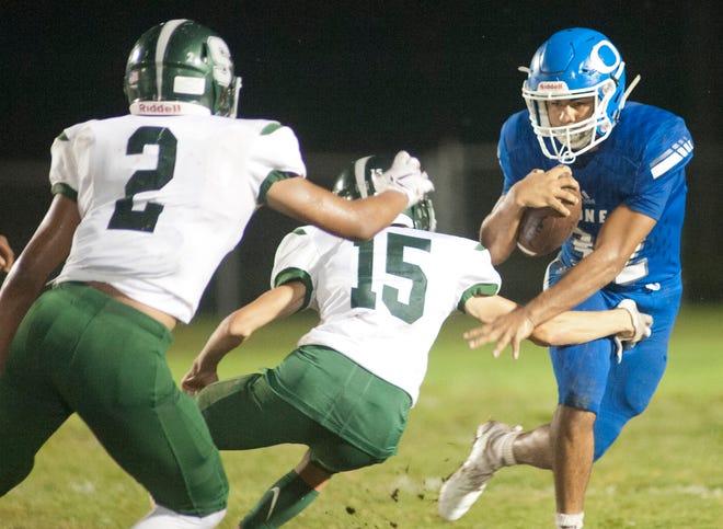 Oldham County running back Lucas Jones tries to avoid the pursuit of South Oldham defensive back John Downing, left, and South Oldham defensive back Evan Devasier, center, as Oldham County hosts South Oldham in the cross-county high school football rivalry.September 21, 2018
