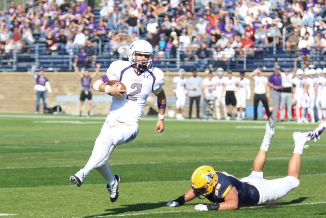 USF's QB Caden Walters escapes pressure from an Augustana defender.