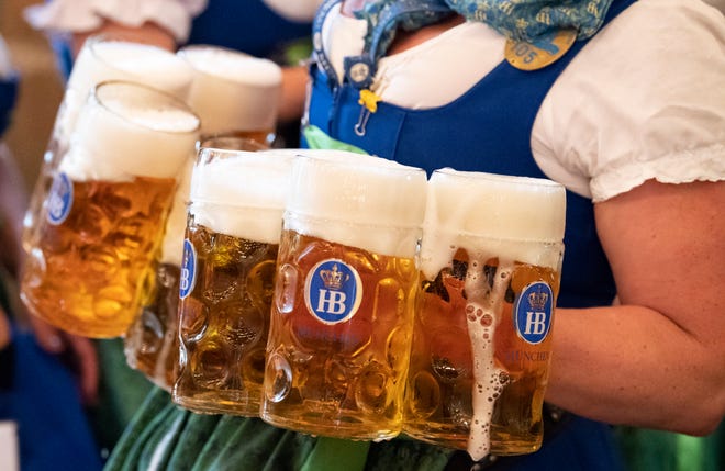 A waitress carries mugs of beer during the opening day Oktoberfest.