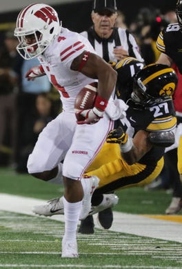 Wisconsin wide receiver A.J. Taylor picks up 22 yards on a reception despite the efforts of Iowa defensive back Amani Hooker.