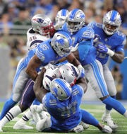 Detroit Lions defenders A'Shawn Robinson (91) and Romeo Okwara (95) tackle New England Patriots running back Sony Michel during the first quarter Sunday, Sept. 23, 2018 at Ford Field.