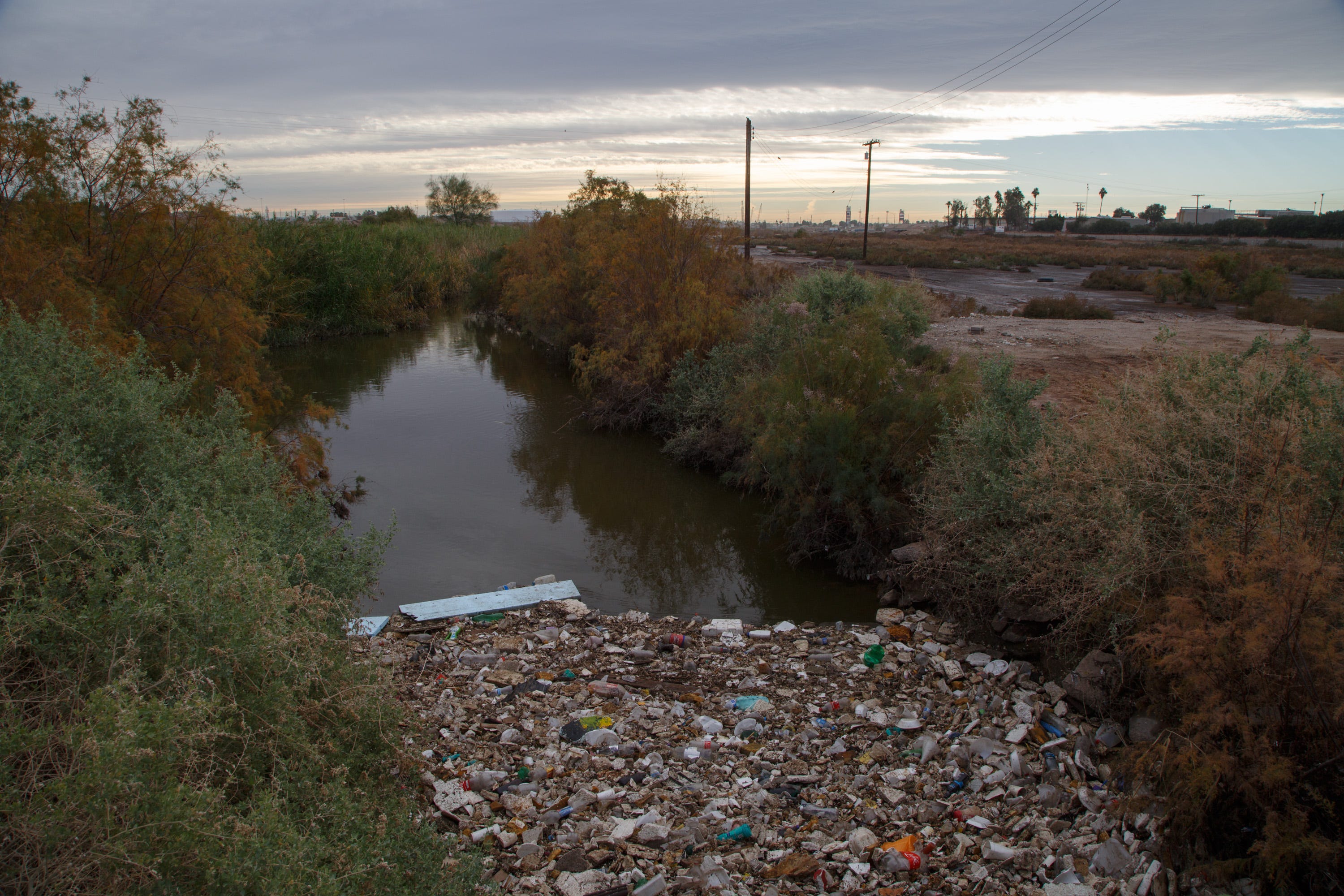 Floating trash collects in the New River near the border in Calexico.