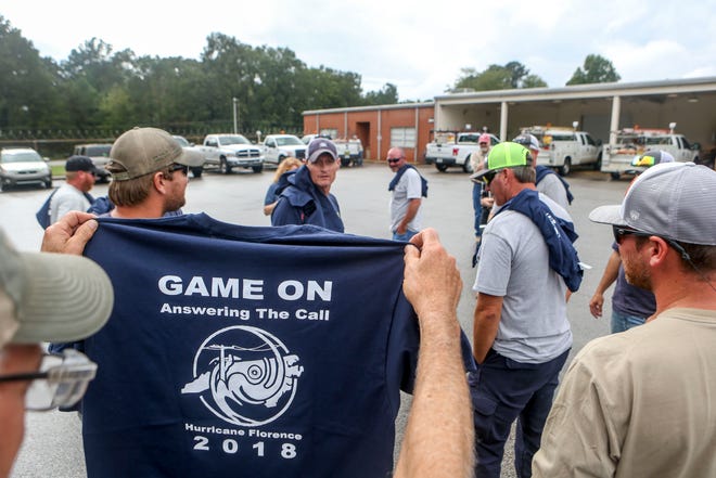 A linemen that was dispatched to assist with recovery efforts after Hurricane Florence holds up a t-shirt made for the team that returned at Southwest Tennessee Electric in Jackson, Tenn., Monday, Sept. 24, 2018.