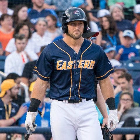 Tim Tebow picks up a bat at the end of the second...