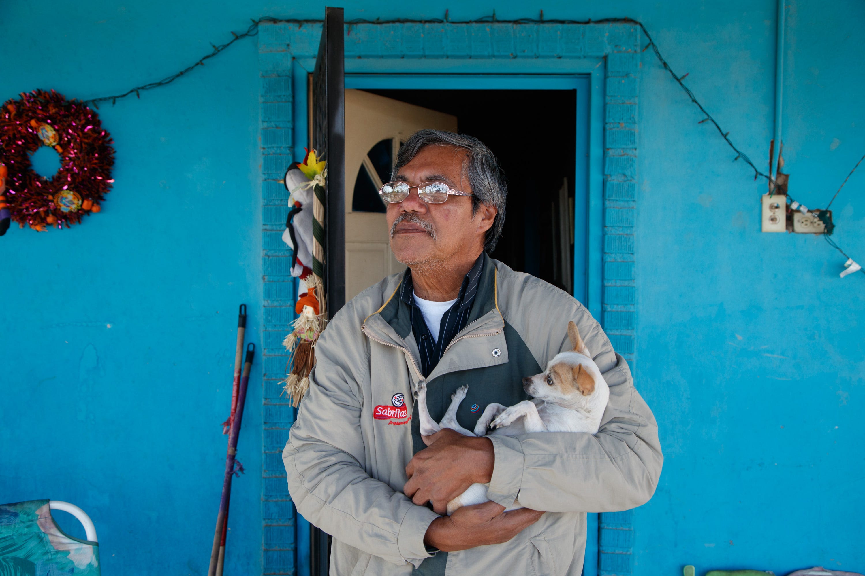 Julian López stands outside his home in a neighborhood next to several factories in Mexicali.