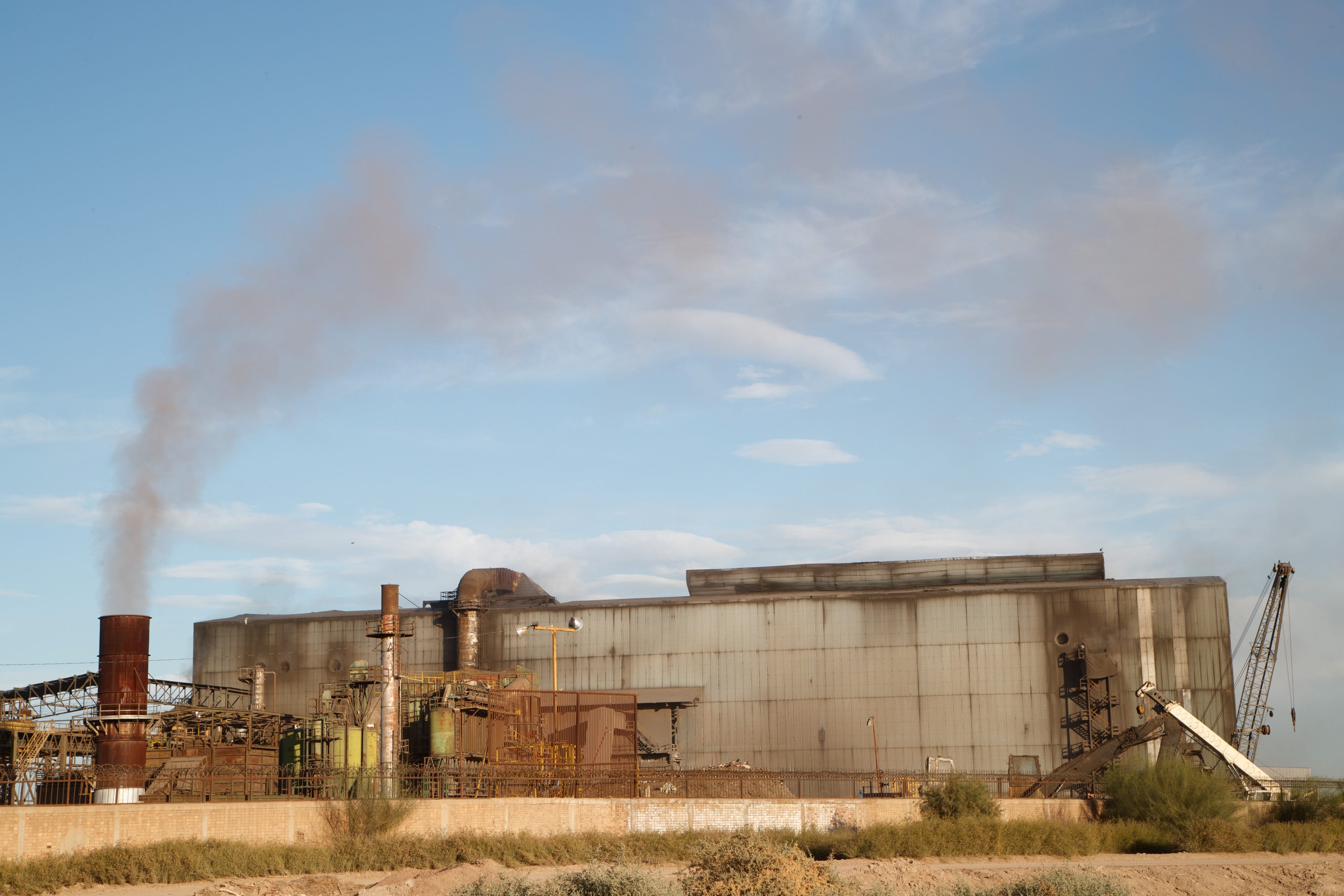 Smoke floats into the air at the Grupo Simec steel mill, which is flanked by several homes and farmland south of Mexicali.