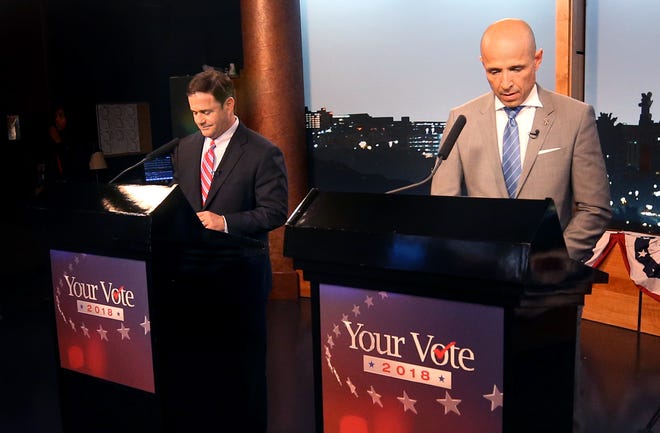 Gubernatorial candidates Republican Doug Ducey, left, and Democrat David Garcia prepare in the last minutes before a televised debate in the AZPM studios, Tuesday, Sept. 25, 2018, in Tucson.
