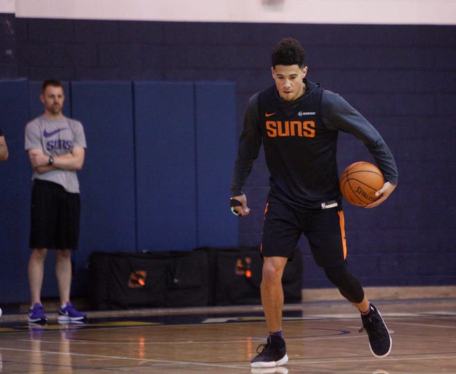 Suns guard Devin Booker works his left hand Wednesday during a training camp practice at Northern Arizona.