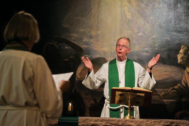 In this Aug. 8, 2018 photo, Rev. Stephen Askew, right, and Rev. Patricia Tanzer Askew, perform a Holy Eucharist and Healing service at St. Matthew's Episcopal Cathedral in Laramie, Wyo. The cathedral named after the biblical disciple, has been the religious home of many historical figures of Laramie and continues to serve the community.