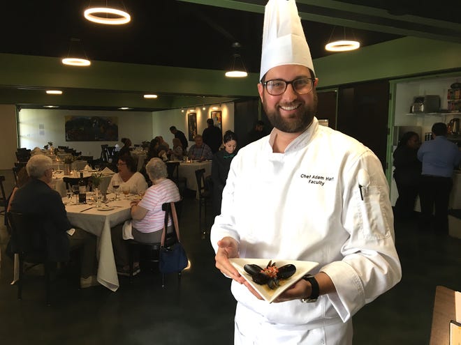 Adam Hart, chef instructor for the culinary arts and restaurant management program at Oxnard College, poses with a plate of saffron-infused mussels at The Bistro, the student-run restaurant on campus. After skipping spring semester, The Bistro has reopened for fall with a new look, and with a switch from dinner to lunch service. "The mood is lighter, and faster, than dinner," says Hart.