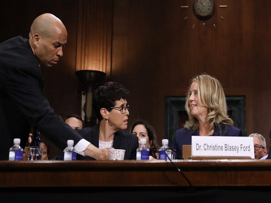 epa07051311 Sen. Cory Booker (D-NJ) (L), member of the Judiciary Committee of the Senate, delivers coffee to Christine Blasey Ford (right) while she testifies before the hearing before the Judiciary Committee of the Senate on the appointment of Brett Kavanaugh as Deputy Judge of the United States Supreme Court, Capitol Hill, Washington, DC, United States, on September 27, 2018. US President Donald J. Trump's Candidate for Judge Associate at the US Supreme Court, Brett Kavanaugh, is engaged in a tumultuous confirmation process while many women have accused Kavanaugh of misconduct. EPA-EFE / McNamee Win / POOL ORG XMIT: DCAH211