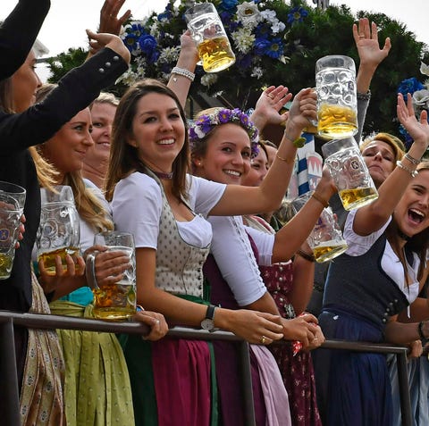 People lift beer mugs during a parade as part of t
