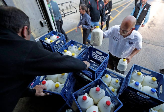 Mark Petersen, right, of Petersen Dairy Farm helps to load 100 gallons of milk on a St. Joseph Food Program truck as part of a #10gallonchallenge on Thursday at Festival Foods on Northland Avenue in Appleton.