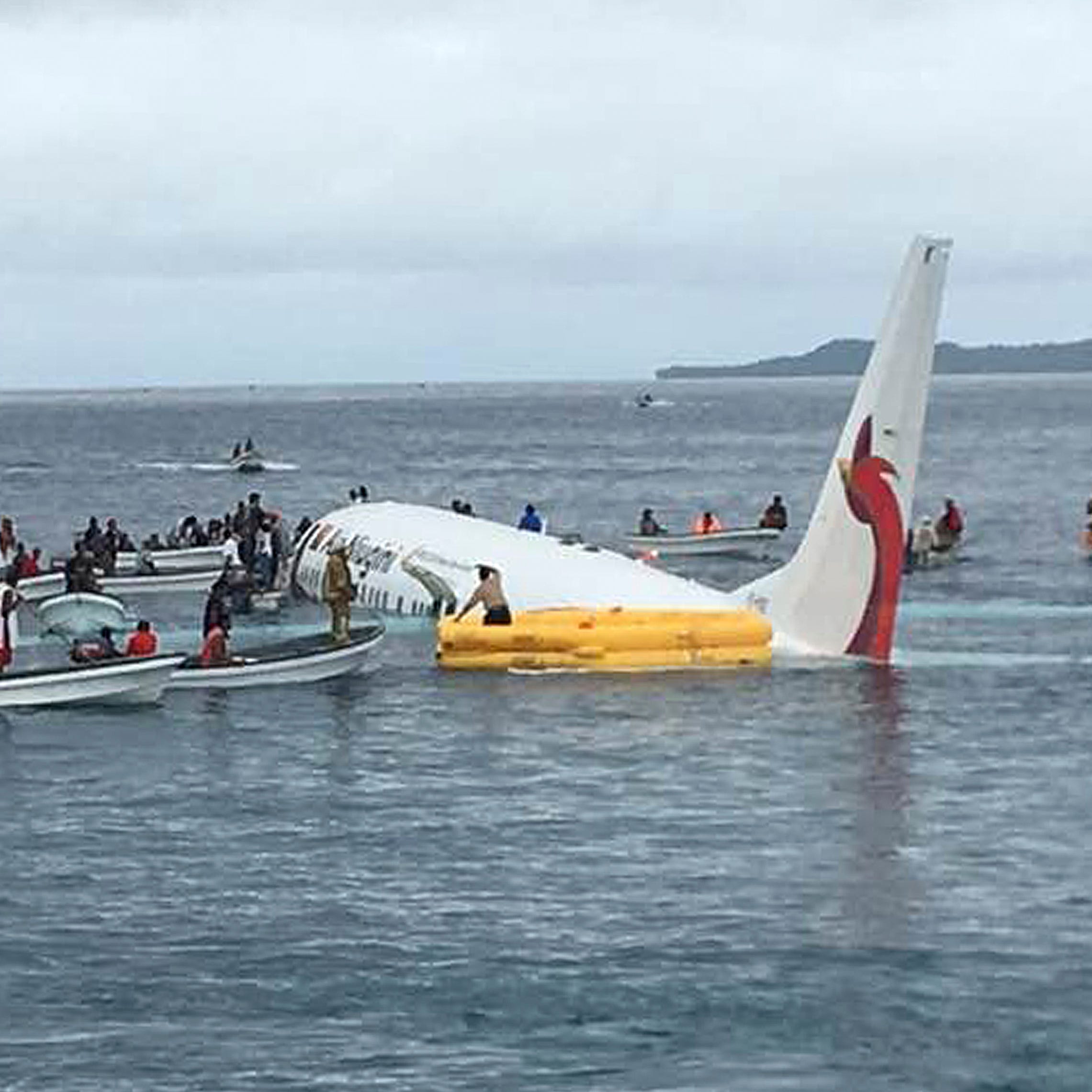 Local fishing boats move in to recover the passengers and crew of Air Niugini flight following the plane crashing into the sea on its approach to Chuuk International Airport in the Federated States of Micronesia.